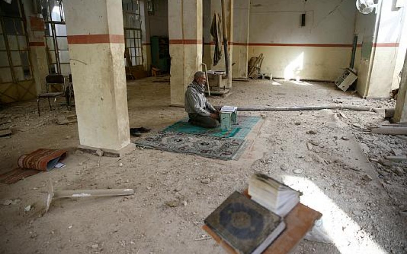 پیرمردی که در مسجد تخریب شده در اثر بمباران در شهر دوما (غوطه شرقی) نماز می‌خواند (رویترز)