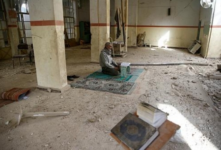 پیرمردی که در مسجد تخریب شده در اثر بمباران در شهر دوما (غوطه شرقی) نماز می‌خواند (رویترز)