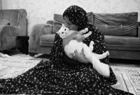 مادری که بعد از نماز، گربه‌اش را بغل می‌کند